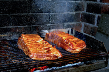 pork ribs marinated grilling on hot burning charcoal barbecue close-up
