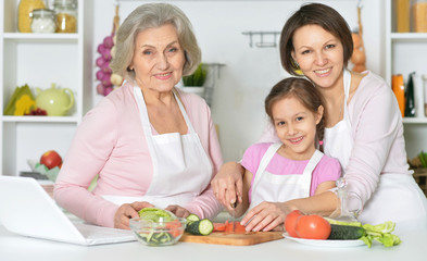 Mother, daughter and grandmother cooking together 