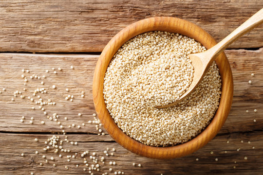 Raw quinoa close up in a wooden bowl. top view horizontal background