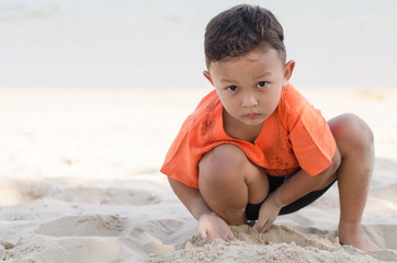 Asian Happy little boy 4-5 year on vacation having fun playing sand on beach