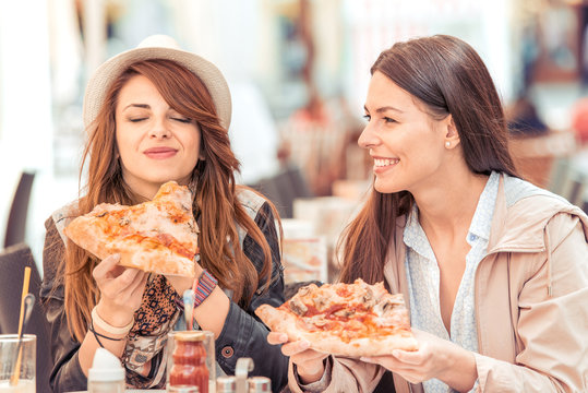Girls eating pizza in cafeteria