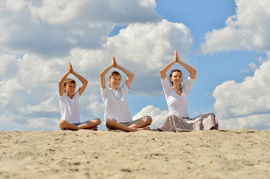 family on the beach doing yoga - Powered by Adobe