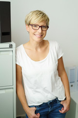 moderne frau steht im büro und lächelt