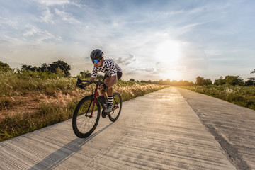 Young man cyclist at sunset