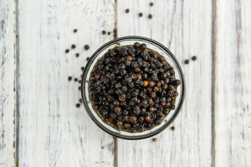 Preserved black Peppercorns on a wooden table