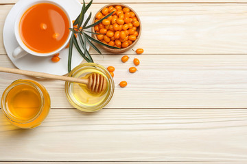 Sea buckthorn in wooden bowl, honey, Sea buckthorn juice on wooden table. top view with copy space