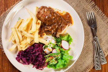 Pork roulade with french fries with salad