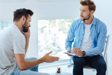 Obraz premium Nice sympathetic doctor listening to his patient