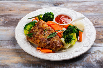 Fried pork steak with vegetables garnish. Copy space