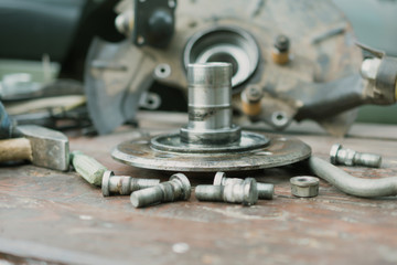 Old, oiled wheel hub lies on a wooden table