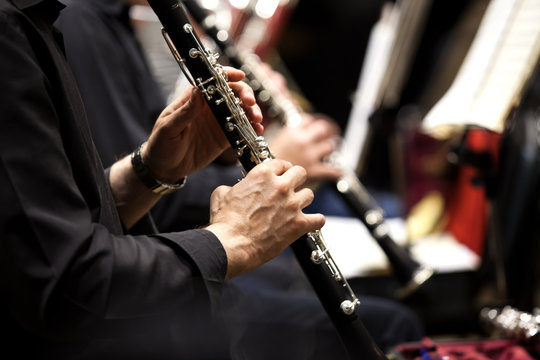  Hands of man playing the clarinet in the orchestra