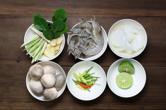 Ingredient of tom yum ( Lemongrass, Galangal, kaffir lime leaf,shrimp, onion, Paddy straw mushroom ,chili and lime) in white bowl on wooden background, thai food, prepare food.
