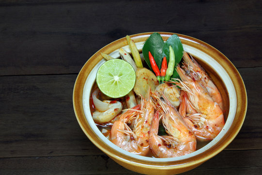 Tom Yum Kung Shrimp clear soup on wooden background, Thai food, cuisine.