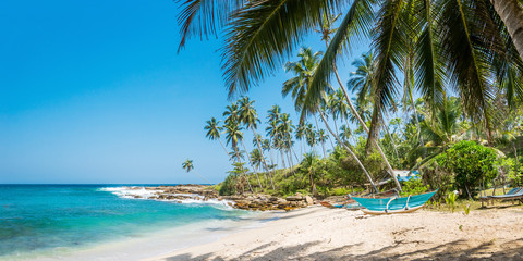 Panoramic view of the beach with traditional wooden fishing boats in Sri Lanka. - obrazy, fototapety, plakaty