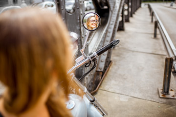 Woman on the motorcycle with reflection in the mirror