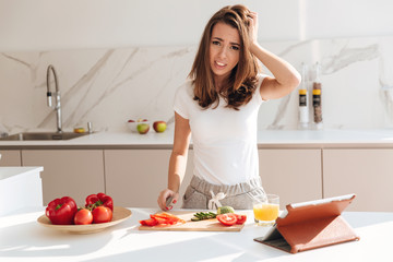 Confused young woman holding knife