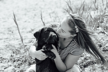 beautiful girl is playing with brown labradors