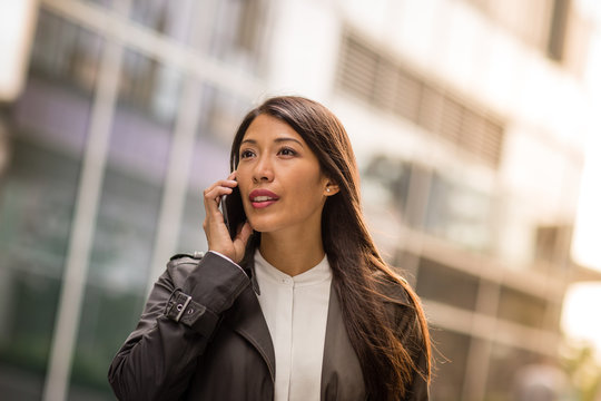 Woman using smartphone walking in city - Powered by Adobe
