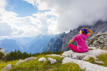 Fototapeta na wymiar Active woman exercising in the nature above the beautiful valley.