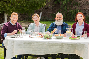 smiling family during dinner at countryside