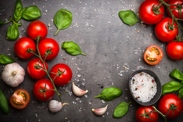 Fresh tomatoes on black slate background. Top view copy space.