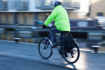 Man cycling with safety helemnt and high visibility jacket