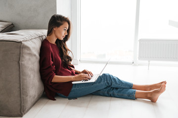 Smiling young woman working on laptop computer