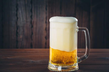 Mug of beer on the wooden background