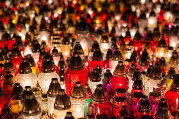 Fototapeta premium Burning candles at a cemetery during All Saints Day
