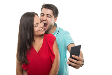 Attractive young couple taking selfie being playful