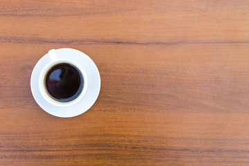 Cup of coffee on wooden table. Top view