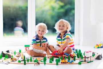 Children play wiht toy train. Kids wooden railway.