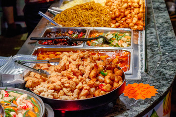 Variety of cooked Chinese food on display for takeaway at Camden Market in London