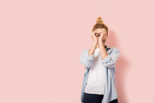 Young Beautiful Woman With Hands Arranged In Heart Shape