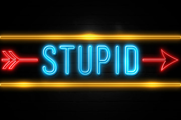 Stupid  - fluorescent Neon Sign on brickwall Front view