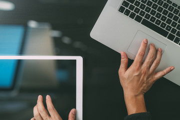 cyber security internet and networking concept.Businessman hand working with  laptop computer and digital tablet background