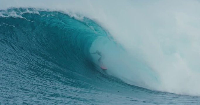 Surfer rides giant blue ocean wave. Shot on RED in 4k. Big wave surfing. Slow motion