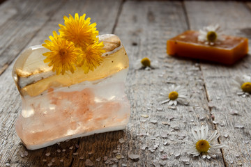 Fototapeta na wymiar Natural handmade soap and chamomile on wooden background. Selective focus.