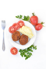 Homemade cutlets with mashed potatoes and tomatoes.