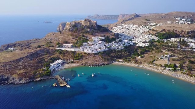 Aerial drone video of iconic ancient Acropolis and village of Lindos, Rodos island, Aegean, Dodecanese, Greece