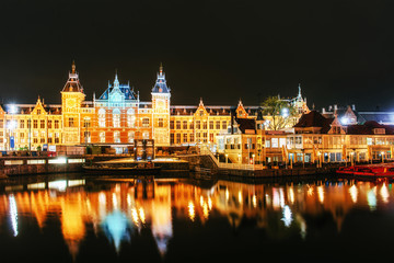 Naklejka na ściany i meble Night illumination of buildings and boats near the water in the canal.