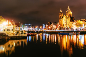 Naklejka na ściany i meble Night illumination of buildings and boats near the water in the canal.