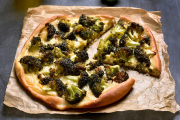 Pizza with broccoli and cheese on paper