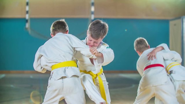 Two students are wearing a red belt in judo and two other students are wearing a yellow belt.