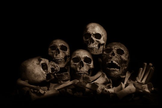 Awesome pile of skull human and bone on wooden, black cloth background. Still Life style, selective focus,