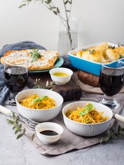 Lunch with curry pasta noodles in bowls and vegetables with turmeric