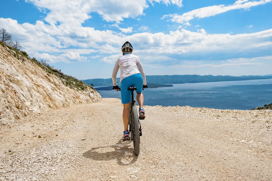 Woman biking coast of croatia