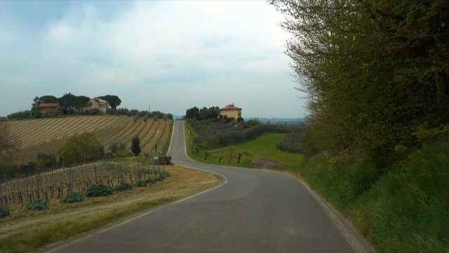 tuscanian hills through the windscreen of car on a road