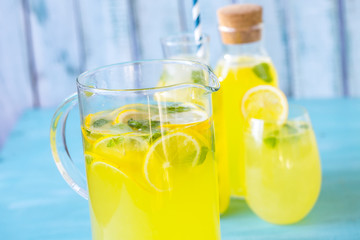 Fototapeta premium fresh lemonade with ice and mint on a blue background