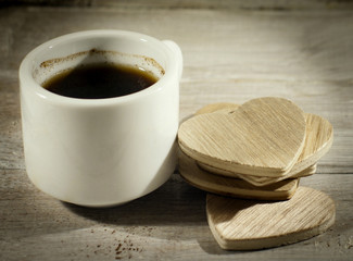 Close up cup of coffee with wooden heart